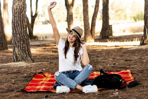 秋の日に畑の遊びの毛布の上に帽子をかぶった笑顔の若い女性のイメージ — ストック写真