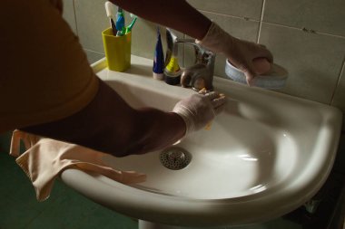 Ev işi, lavaboyu eldiven, su ve deterjanla temizle.