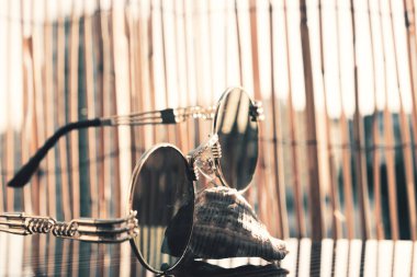 Dışarıda bambu arka planda yuvarlak mercekli klasik güneş gözlüğü modeli. Seçici odak 