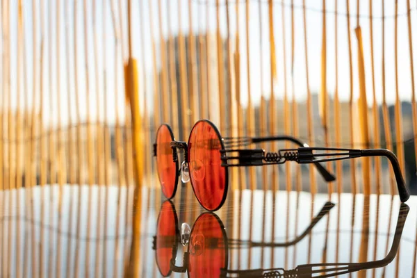 Sluneční brýle steampunk s červenou kulatou čočkou zůstávají na stole za slunečného letního dne. Selektivní zaměření — Stock fotografie