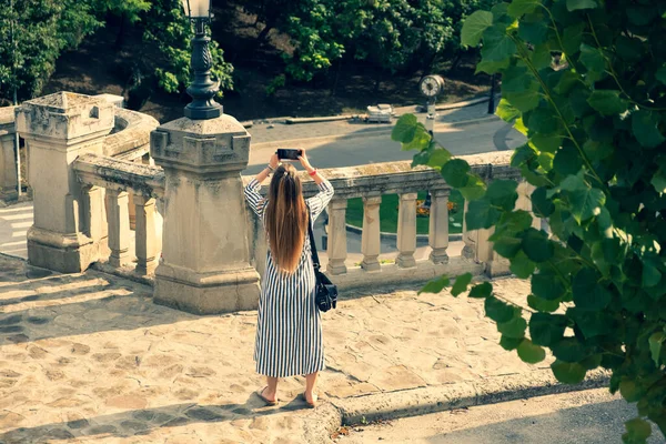 Menina bonita com cabelos longos fazendo fotos com seu telefone. Foco seletivo — Fotografia de Stock