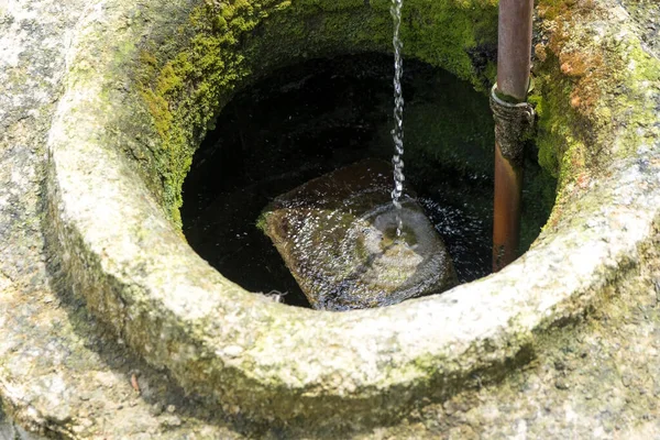 Very old fountain in which clean water flows. Located in the yard of a country house — Stock Photo, Image