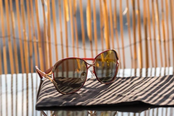 Сонцезахисні окуляри для жінок з великою круглою лінзою та металевою рамкою, що відображають сонце. Вибірковий фокус — стокове фото