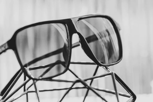 Modelo de gafas de sol retro aviator con lentes negras y montura negra de material plástico que refleja el sol en un primer plano de día de verano. Enfoque selectivo — Foto de Stock