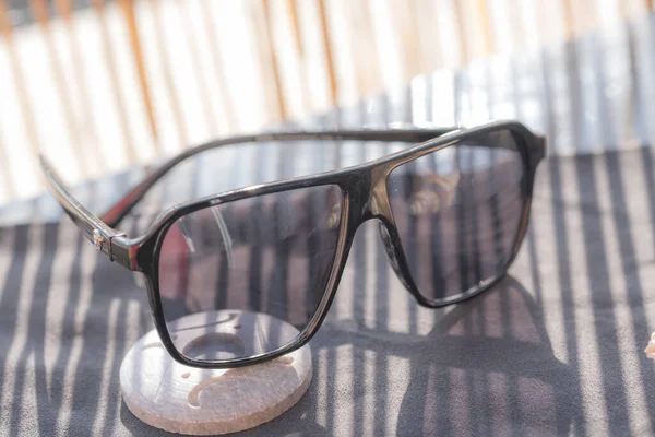 Модель сонцезахисних окулярів ретро-авіатора з чорними лінзами та пластиковим матеріалом чорної рамки, що відображає сонце в літній день крупним планом. Вибірковий фокус — стокове фото