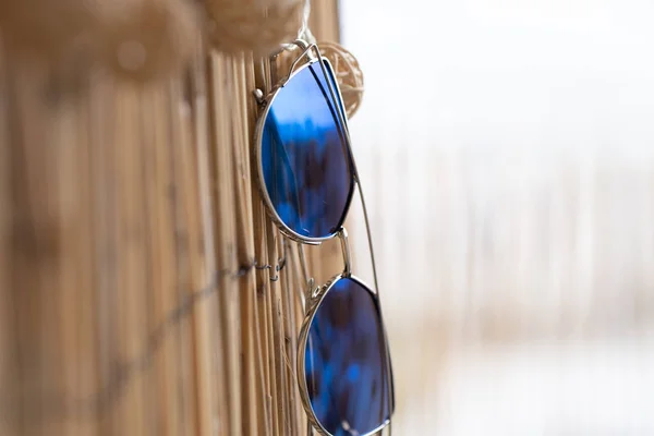 Cat Eye Sonnenbrille Modell Profil für Damen mit blauen Gläsern bleiben auf einem Bambuszaun Nahaufnahme. Selektiver Fokus — Stockfoto