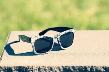 Güneşli bir günde siyah lensli ve beyaz çerçeveli klasik güneş gözlüğü modeli. Seçici odak