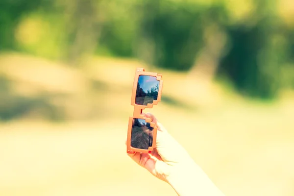 Modelo de pixel de óculos de sol vermelhos com lentes pretas fecham em um dia ensolarado. Foco seletivo — Fotografia de Stock