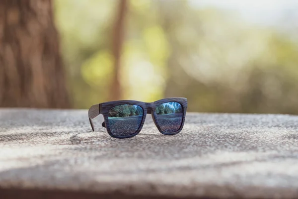 Modelo de gafas de sol clásicas con lentes azules y montura azul en un primer plano de día soleado. Enfoque selectivo — Foto de Stock