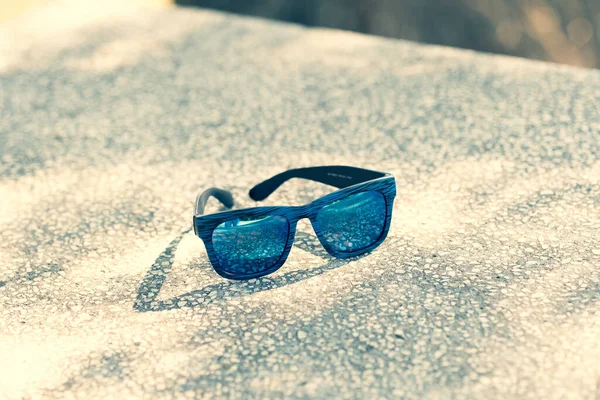 햇빛이 잘 드는 날에는 파란색 렌즈와 파란색 틀이 달린 선글라스를 끼고 있다. 선택적 초점 — 스톡 사진