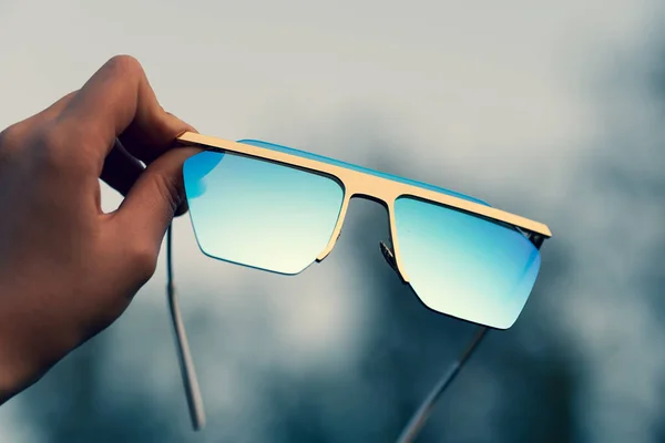 Негабаритні сонцезахисні окуляри тримаються вручну крупним планом. Вибірковий фокус — стокове фото