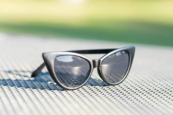 Kočičí oko sluneční brýle černý model střílet v letní den detailní záběr. Selektivní zaměření — Stock fotografie