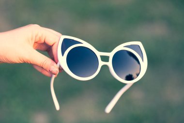 Kedi gözü güneş gözlüğü yakın plan dışında el kamerasıyla çekiliyor. Seçici odak 