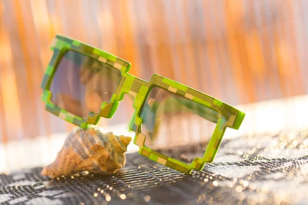 Gafas de sol de píxel verde con lentes negras de primer plano en un día soleado. Enfoque selectivo — Foto de Stock