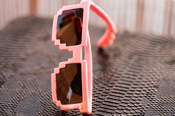 핑크 픽셀 선글라스 모델과 검은 렌즈가 여름철에 겹쳐져 있다. 선택적 초점 — 스톡 사진