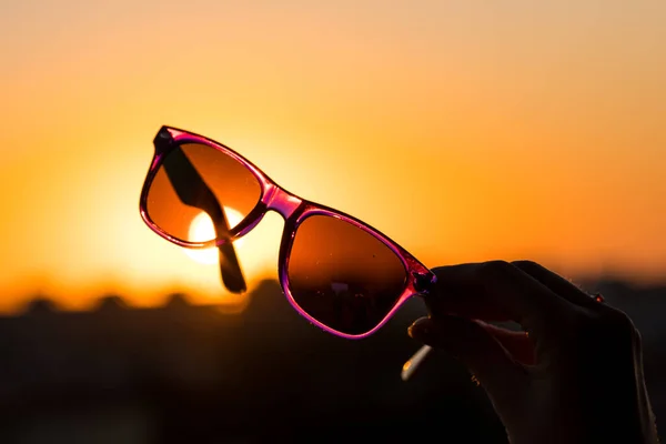 Modelo de gafas de sol clásicas sostener a mano disparar en un primer plano día de verano. Enfoque selectivo — Foto de Stock