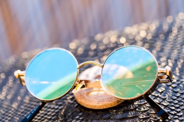Steampunk sunglasses model with round lenses in a summer day closeup. Selective focus  clipart