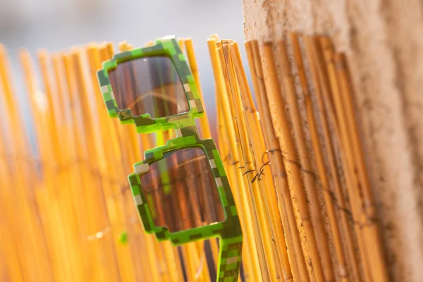 Green thug life pixel model sunglasses shoot outside in a sunny day closeup. Selective focus