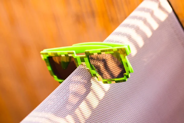 Green thug life pixel model sunglasses shoot outside in a sunny day closeup. Selective focus