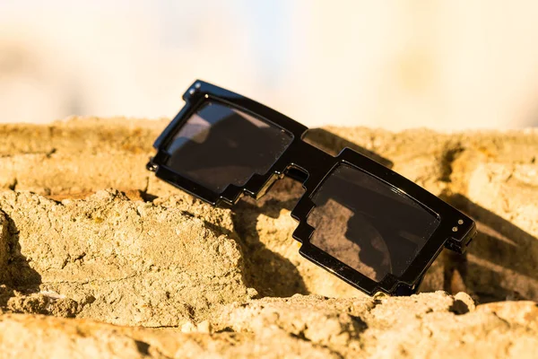Occhiali da sole pixel neri con lenti nere primo piano in una giornata di sole. Focus selettivo — Foto Stock