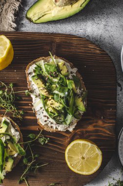 Lezzetli taze peynir, taze gevrek ekmek arası peynir avokado ve salatalık ve üstte sağlıklı tohum