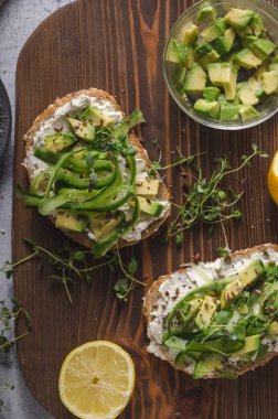 Lezzetli taze peynir, taze gevrek ekmek arası peynir avokado ve salatalık ve üstte sağlıklı tohum