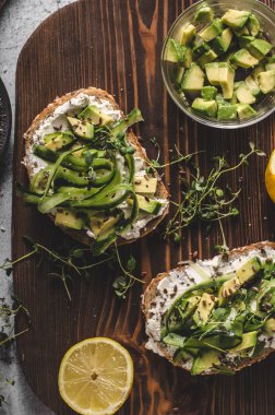 Lezzetli taze peynir, taze gevrek ekmek arası peynir avokado ve salatalık ve üstte sağlıklı tohum