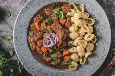 Ev yapımı makarna ve otlar ile yavaş yavaş pişmiş lezzetli güveç