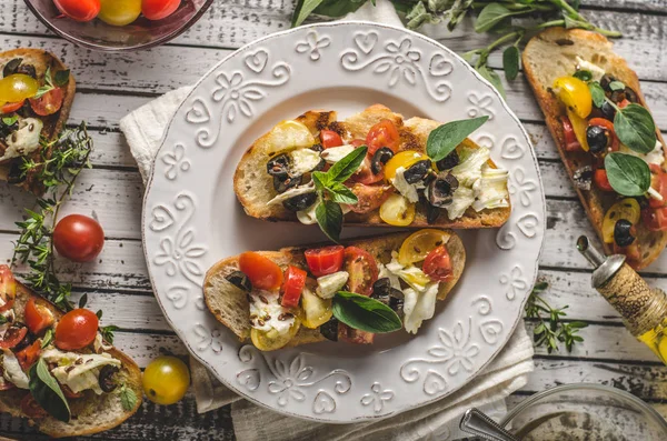 Crostini met tomaten en olijven op mooie plaat — Stockfoto