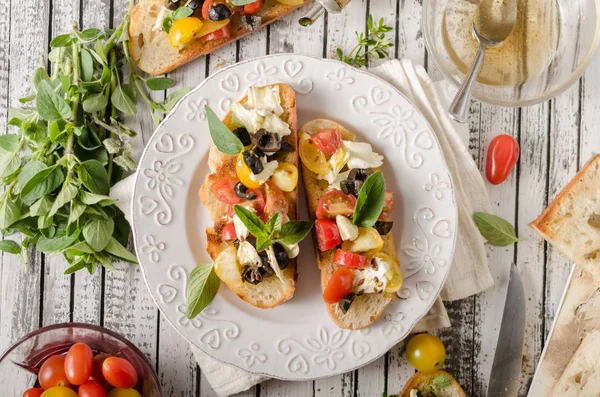 Crostini mit Tomaten und Oliven auf schönem Teller — Stockfoto