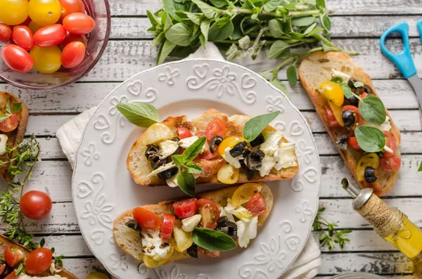 Crostini con tomates y aceitunas en hermoso plato — Foto de Stock