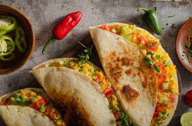 Çırpılmış yumurta, çıtır tortilla, peynir, şifalı ot ve sebze.