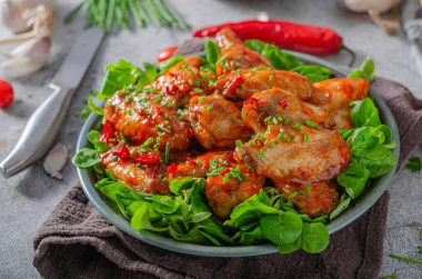 Sarımsaklı tavuk kanadı, acı biber ve kırmızı sos.