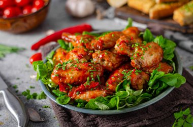 Sarımsaklı tavuk kanadı, acı biber ve kırmızı sos.