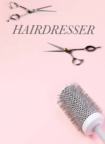 Várias ferramentas de cabeleireiro. Tesoura e escova de cabelo. Em um fundo rosa . — Fotografia de Stock