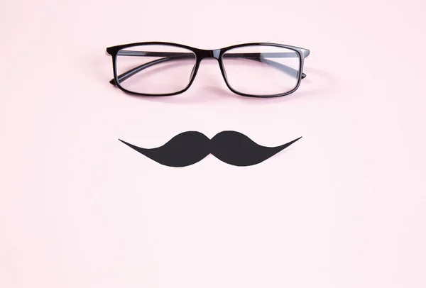 Gafas y bigote sobre un delicado fondo rosa. tarjeta de regalo para el día de los padres . —  Fotos de Stock