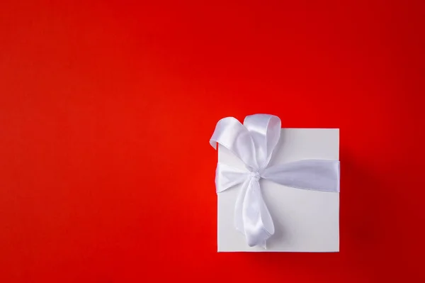 Stock image  White Gift box on a red background. Space for text. 