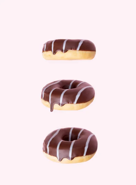 Três donuts em esmalte de chocolate escuro com listras de chocolate branco — Fotografia de Stock