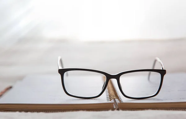 Image d'un bloc-notes ouvert placé dans le lit avec des lunettes .fond flou — Photo
