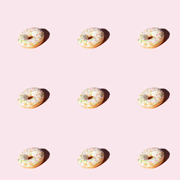 Verschillende Donuts met witte glazuur en kleurrijke zoete suikersticks. — Stockfoto