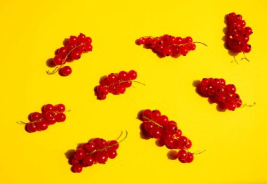 Parlak güneş ışığında sarı bir zemin üzerinde olgun kırmızı üzümler