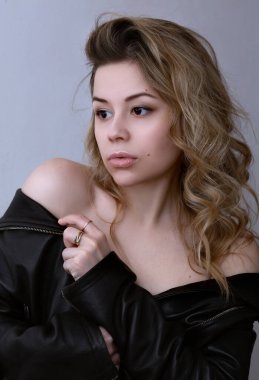 Deri ceketli, çıplak omuzlu genç bir kadın.