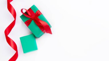 Kırmızı kurdeleli beyaz arka planda Noel hediyeleri 