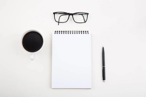 White notepad with black pen and glasses on light table, Stock Photo