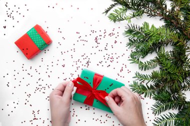 Noel hediyesini kırmızı kurdeleyle tutan eller 