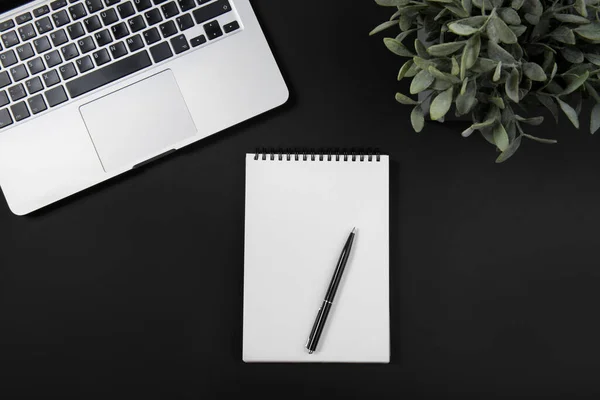 Black office desk with laptop, smartphone, notebook and pen. Top view — Stock Photo, Image