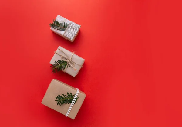 Tres regalos de Navidad se encuentran sobre un fondo rojo brillante —  Fotos de Stock