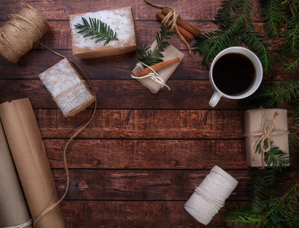Una taza de café está sobre la mesa junto a los regalos de Navidad — Foto de Stock