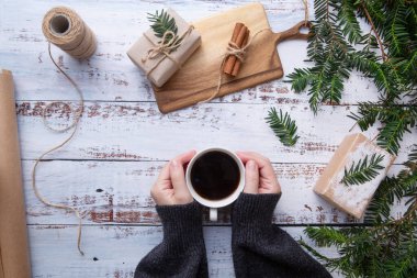  Kız masaya hediyelerle bir fincan kahve koyuyor.