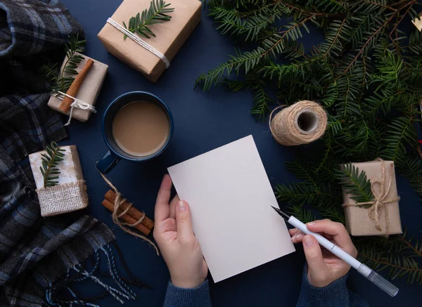  Mavi bir arka planda Noel listesi yazan bir kızın elleri
